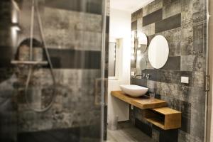 a bathroom with a sink and a mirror and a shower at Palazzo Murat B&B in Monopoli