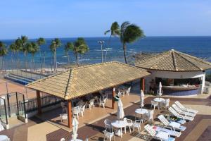 a resort with chairs and umbrellas on the beach at Ondina Apart Hotel AP in Salvador