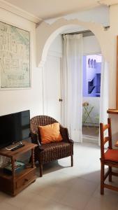科尼爾－德拉弗龍特拉的住宿－Conil con sabor a mar，客厅配有椅子和电视