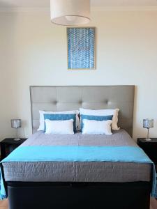 a bedroom with a large bed with blue pillows at Ponte House in Porto Moniz