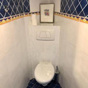 - białą toaletę w łazience wyłożonej niebieskimi kafelkami w obiekcie St. Georges Atelier w mieście Piran