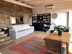 uma sala de estar com um sofá branco e uma parede de tijolos em St. Georges Atelier em Piran