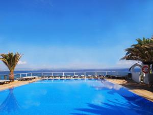 uma grande piscina com vista para o oceano em Hotel Club Sunway Punta Prima em Es Pujols