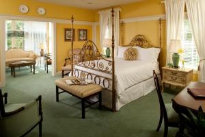 ein Schlafzimmer mit einem Bett, einem Stuhl und einem Tisch in der Unterkunft Fairview Inn in Jackson