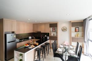 a kitchen with a table with chairs and a refrigerator at Prairie Villa in Ban Khlong Ta Khet