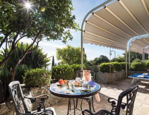 una mesa y sillas en un patio con sombrilla en Hotel Bel Soggiorno, en Taormina