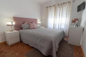een slaapkamer met een groot bed en 2 nachtkastjes bij O Veleiro Apartment in Nazaré