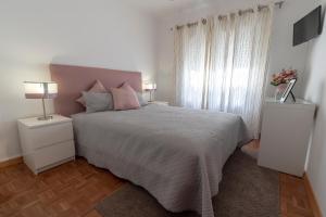 een slaapkamer met een groot bed en twee nachtkastjes bij O Veleiro Apartment in Nazaré