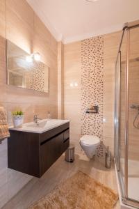 een badkamer met een wastafel, een toilet en een douche bij O Veleiro Apartment in Nazaré