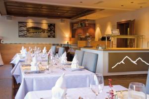 uma sala de jantar com mesas e cadeiras brancas em Pension Angelika em Pettneu am Arlberg