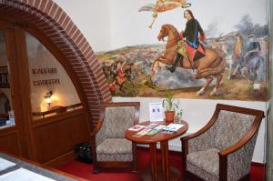 ein Zimmer mit einem Wandgemälde mit einem Tisch und Stühlen in der Unterkunft Hotel Petr in Karlsbad