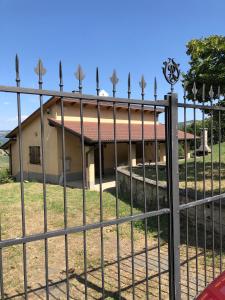 a fence in front of a house with a building at Capannina Vesale in Sestola