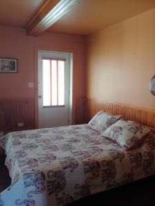 a bedroom with a bed with a quilt on it at Gite les 2 Soeurs in Roberval