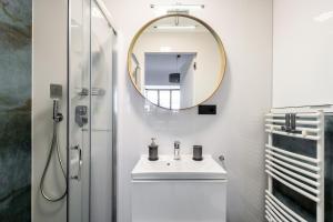 een badkamer met een wastafel en een spiegel bij Studio Centrum Pawia Deluxe in Warschau