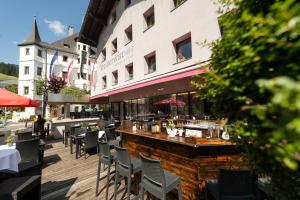 a restaurant with chairs and a bar in front of a building at Hotel Steinerwirt1493 in Zell am See