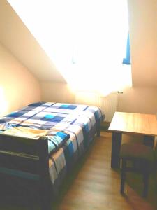 a bedroom with a bed and a table in a room at Tawerna Akropolis in Ostrów Mazowiecka