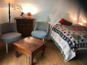 una camera con un letto e due sedie e un tavolo di Bungalow meublé près du lagon a La Saline Le Bains