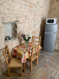 a table and chairs with a vase of flowers on it at fiori catene tra le torri in Conversano