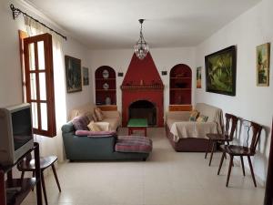 sala de estar con sofá y chimenea en Bellavista - Carratraca, en Carratraca