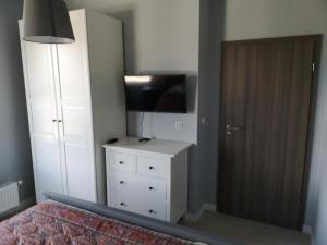 a bedroom with a bed and a tv and a dresser at AQUAMARINA ONYX 147 in Międzyzdroje