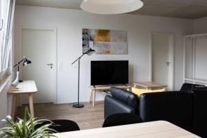 a living room with a couch and a flat screen tv at Atrium Apartments in Schaffhausen