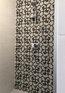 a shower with a black and white patterned shower curtain at Finca Zayas Casa Rural & Guest Suites in Periana