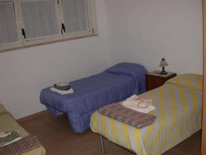 ポリコーロにあるCasa Vacanze Agriturismo BioMeleの紫のシーツが備わるベッド2台が備わる客室です。
