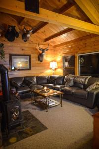 ein Wohnzimmer mit einem Ledersofa und einem Tisch in der Unterkunft Colgate Lake Lodge in East Jewett