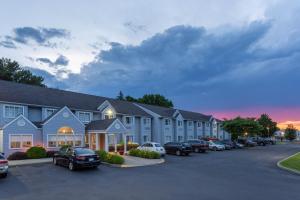 um grande edifício com carros estacionados num parque de estacionamento em Microtel Inn & Suites by Wyndham Bethel/Danbury em Bethel