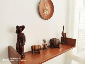 a shelf with wooden figurines and a clock on a wall at Marina's Home By The Sea in Bat Yam