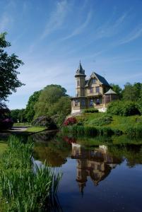 a house sitting on top of a hill next to a river at Café Mandeltårtan B&B VillaFloraViola in Ronneby