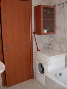 ein Badezimmer mit einer Waschmaschine und einem Waschbecken in der Unterkunft Casa Vacanze Agriturismo BioMele in Policoro