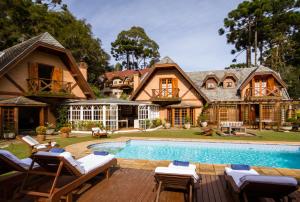an estate with a swimming pool and a house at Pousada Da Pedra in Campos do Jordão