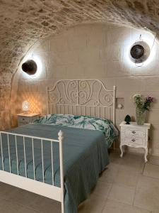 a bedroom with a bed and a stone wall at fiori catene tra le torri in Conversano
