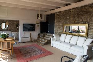 salon z białą kanapą i kamienną ścianą w obiekcie St. Georges Atelier w mieście Piran
