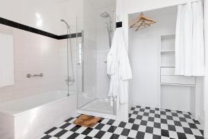 biała łazienka z prysznicem i wanną w obiekcie Quinta do Valdalágea w mieście Peso da Régua