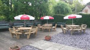 a group of tables and chairs with umbrellas at Winchester Arms in Trull