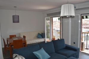 - un salon avec un canapé bleu et une table dans l'établissement Apartamento en el centro histórico, à Cordoue