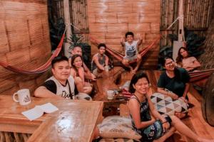 a group of people sitting around a table in a room at Balay Hayahay Clohaki Hostel in General Luna