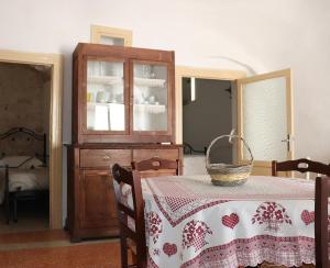 a dining room with a table and a china cabinet at Trullo Zia Nina in Alberobello +16 photos