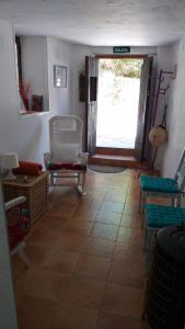 d'un salon avec une table, des chaises et une fenêtre. dans l'établissement Casita Collado 1, à Alájar