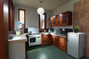 a kitchen with wooden cabinets and a white refrigerator at Villa Sambal in Yogyakarta