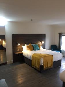 um quarto de hotel com uma cama grande com almofadas amarelas e azuis em Base Dingle em Dingle