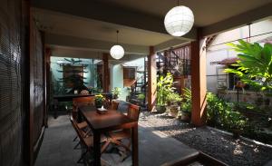 a dining room with a table and chairs and plants at Villa Sambal in Yogyakarta