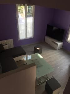 a living room with a table and a tv at La maison parisienne maison deux pièces à louer au pied du métro in Maisons-Alfort