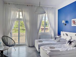 a bedroom with two beds and a large window at Willa Moryń in Moryń