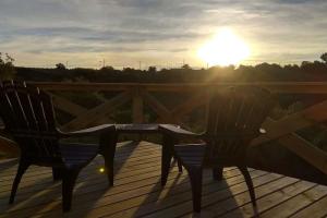 two chairs on a deck with the sun in the background at Villa Serrana Relax & Confort in Villa Serrana