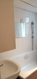 a bathroom with a sink and a mirror and a tub at Carib Inn in Manchester +8 photos