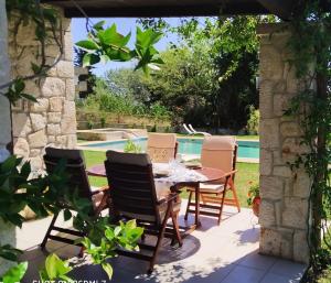 a patio with a table and chairs next to a pool at Siviri Traditional Stone House in Siviri