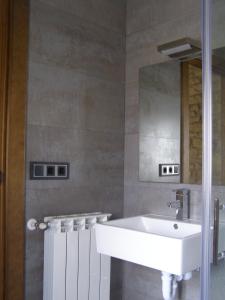 ein Badezimmer mit einem weißen Waschbecken und einem Spiegel in der Unterkunft CASA RURAL FERNANDOEGEA in Ayesa